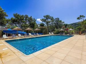 a swimming pool with chairs and umbrellas at Chalet 3 étoiles - eeicci in Cargèse +17 photos