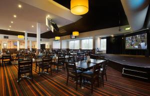 un restaurante con mesas y sillas y un bar en Nightcap at Gateway Hotel, en Corio