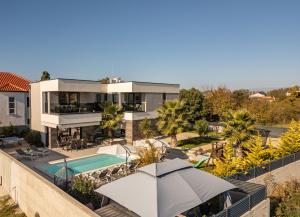 a house with a swimming pool and an umbrella at Villa Nina ZadarVillas in Zaton