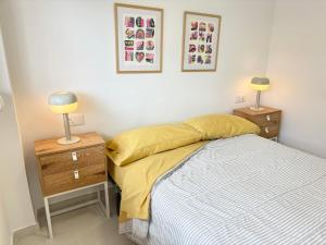 a bedroom with a bed and a nightstand and two lamps at Escápate al Sol Apartamento con Piscina y Playa Cercana in Playa Pobla de Farnals +32 photos