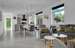ein Wohnzimmer und eine Küche mit einem Sofa und Tischen in der Unterkunft Nice Home In Ebeltoft With Sauna in Ebeltoft