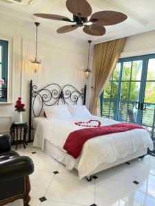 una camera da letto con un letto e un ventilatore a soffitto di Villa La Bella Phan Thiet a Phan Thiet