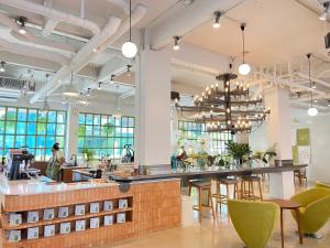 a bar in a restaurant with green chairs at Beat Hotel Bangkok in Bangkok