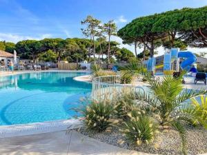 a swimming pool with a slide in a resort at Camping 4 étoiles - Parc aquatique - eeia0i in Le Bois-Plage-en-Ré