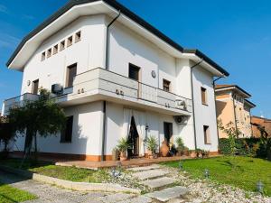a white house with a balcony and some plants at B&B Casa Silingardi in Bagnolo San Vito