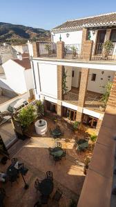 an outdoor patio with tables and chairs in front of a building at Hotel La Casa Grande del Burgo in El Burgo