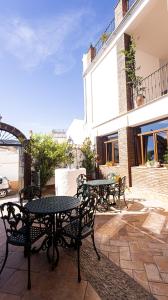 a patio with tables and chairs and a building at Hotel La Casa Grande del Burgo in El Burgo