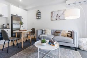 una sala de estar con un sofá y una mesa en The Cornerstone on Inkerman, en Melbourne