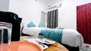 a room with two beds and a wooden table with a table sidx sidx at The Chalet - Cozy Villa with Mini Pool, near Eden Blue Flag Beach, Pondicherry - JR Groups in Puducherry +125 photos