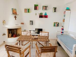 a living room with a table and chairs and a bed at bnb La Casa dei Gatti Paros in Kalami
