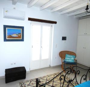 een woonkamer met een deur en een stoel bij La Casa dei Gatti Paros in Kalami