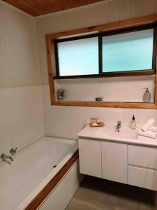 a bathroom with a sink and a tub and a window at Honeycomb Hill of Yarra Valley in Steels Creek