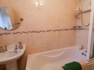 a bathroom with a tub and a sink at Nelly's House in Gort an Choirce +48 photos