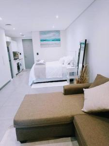 a living room with a bed and a couch at Luxury studio apartment in Umhlanga, South Africa in Umhlanga