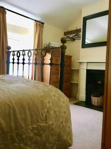 ein Schlafzimmer mit einem Bett und einem Kamin in der Unterkunft HOLIDAY HOUSE TANYGRISIAU SNOWDONIA North Wales in Tanygrisiau