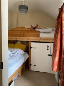 ein Schlafzimmer mit einem Etagenbett aus Holz in der Unterkunft HOLIDAY HOUSE TANYGRISIAU SNOWDONIA North Wales in Tanygrisiau