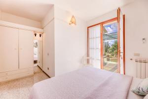 a white bedroom with a bed and a large window at Capo Ai Pini - Bilo Elisa in Lacona