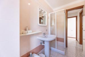 a white bathroom with a sink and a shower at Capo Ai Pini - Bilo Elisa in Lacona