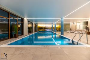 an indoor swimming pool in a house with windows at Apartament Dream View SPA in Szklarska Poręba