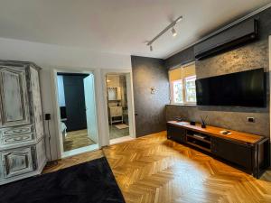 a living room with a large television and a wooden floor at Ozone Home in Cluj-Napoca