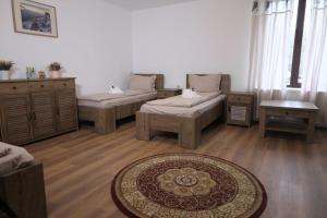 a living room with three beds and a rug at Casa Pelerinului in Alba Iulia