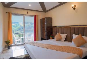 a bedroom with a large bed with a large window at Saanjh Riverside Resort in Mahabaleshwar +52 photos