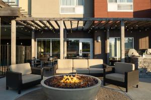una hoguera en un patio con sillas y mesas en TownePlace Suites by Marriott Lafayette South, en Lafayette