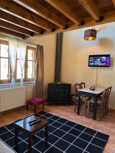 a living room with a table and a tv at Frigias 1 in Arachova