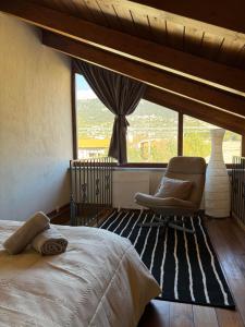 a bedroom with a bed and a chair and a window at Frigias 1 in Arachova