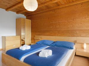 雷克罗塞Apartment Sundance 9 by Interhome的一间卧室配有一张大蓝色的床和两条毛巾