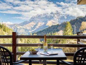雷克罗塞Apartment Sundance 9 by Interhome的山景阳台上的桌子和一瓶葡萄酒