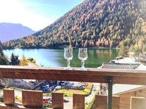 dois copos de vinho em cima de um corrimão de madeira em Apartment Parc B 431 by Interhome em Champex