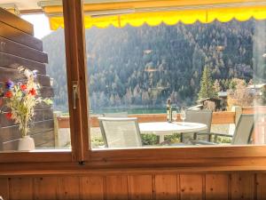 uma janela com vista para uma mesa e cadeiras em Apartment Parc C013 by Interhome em Champex mais 19 fotografias