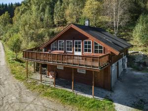 a large wooden house with a deck on a hill at Holiday Home Frigg by Interhome in Arnefjord