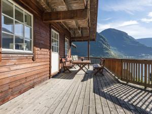 a wooden deck with a table and chairs on a house at Holiday Home Odin by Interhome in Arnefjord +34 photos
