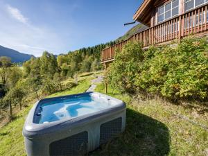 a hot tub sitting in the grass next to a house at Holiday Home Odin by Interhome in Arnefjord