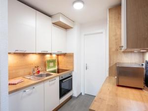 a kitchen with white cabinets and a sink at Apartment Diamant 39 by Interhome in Villars-sur-Ollon