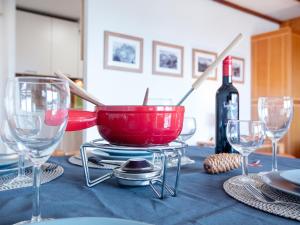 a table with a red bowl and a bottle of wine at Apartment Diamant 39 by Interhome in Villars-sur-Ollon