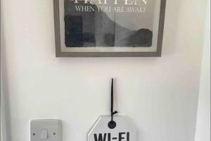 a picture of a sign on a wall with a switch at Ldn Studio-Free Parking-15 min to Elizabeth Line in Dagenham