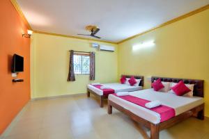 卡兰古特Hotel Savita Calangute的一间设有两张床和电视的客房