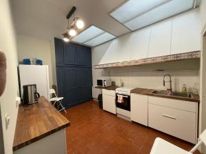a kitchen with white appliances and a blue door at Gîte Le Chastellux in Avallon