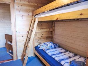 a bunk bed in a wooden room with a ladder at Holiday Home Chalet Ninette by Interhome in Eischoll