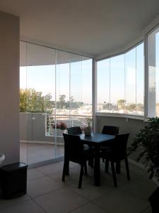 una mesa de comedor y sillas en una habitación con ventanas en Casa vacanze Talenti, en Roma