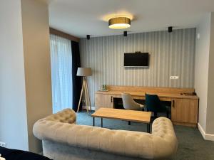 salon z kanapą i stołem w obiekcie Hotel Echo w mieście Cedzyna