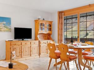 a dining room with a table and a tv at Apartment Le Hameau by Interhome in Les Crosets +30 photos