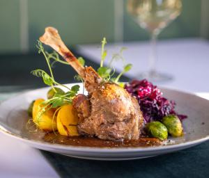 a plate of food with meat and vegetables on a table at Pałac Sieniawa in Sieniawa