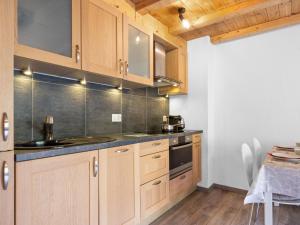 een keuken met houten kasten en een spoelbak bij Apartment Sundance 10-1 by Interhome in Les Crosets