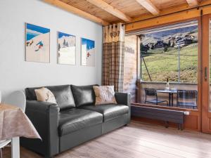 een woonkamer met een leren bank en een tafel bij Apartment Sundance 10-1 by Interhome in Les Crosets