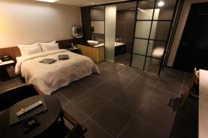 a bedroom with a large bed and a bathroom at Hotel Cacao in Incheon