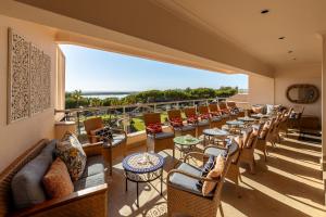 a room with a balcony with tables and chairs at Hotel Quinta do Lago in Quinta do Lago